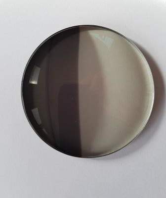 .A grey Transitions lens, only half of it activated to show the difference