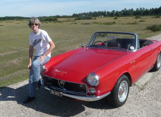 a woman casually sitting beside her red classic car and she's wearing Bigatmo sunglasses